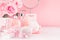 Modern youth bathroom or dressing table design in pastel pink color -  flowers, cosmetic products, bath accessories, jewelry.