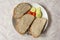 A modest breakfast in the form of three breads with fish spread and as a side dish are small tomatoes and sliced cucumber.