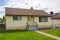 Modest family house with green lawn in front. Old residential house