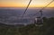 Modular cabins cable car against the bright sky, clouds ans mountains. Cableway - one of the popular urban rides in