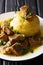 Mofongo Garlic-Flavored Mashed Plantains a dish with pork rind served with meat and broth close-up on a plate. Vertical