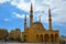 The Mohammad AlAmin Mosque or Blue Mosque with four minarets, in the background is the church of St. George in Beirut, Lebanon