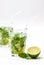 Mohito mojito drink with ice mint and lime on wooden white table.