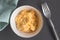 Moist scrambled eggs in bowl on black rustic table - Top view cl