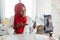 Moisturizer ad, cosmetics and beauty blog. African american muslim woman with bottle of lotion talking to phone camera