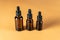 Moisturizing and healing skin serum with vitamin C on a beige background. three dark amber glass pipette droppers with