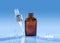 Moisturizing serum with pipette on the top stands on the blue water background