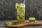 Mojito cocktail drink with lime and mint on dark background with copy space