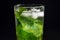 Mojito refreshing cocktail with mint leaves, lime and ice on a black background