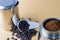 Mokapot coffee brewing with ground coffee beans  on brown background