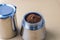 Mokapot coffee brewing with ground coffee beans isolated on brown background