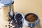 Mokapot coffee brewing with ground coffee beans isolated on brown background