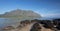 Mokolii Island [also known as Chinamans Hat] rocky beach looking toward Kualoa mountains on the North Shore of Oahu Hawaii USA