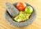 Molcajete Mortar Bowl and Pestle Filled With Guacamole And Ingredients