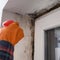 Mold and fungus on a plastic window, a woman removes mold on a window, a woman sprays chemicals on a window from mold.