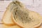 Mold growing rapidly on moldy bread on wooden background. Mildew on a slice of bread. Stale bread, covered with mildew.