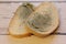 Mold growing rapidly on moldy bread on wooden background. Mildew on a slice of bread. Stale bread, covered with mildew.