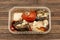 Mold spores on fried vegetables in a plastic food container on a textured wooden background. Concept: Decomposition