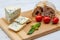 Molded cheese with vegetables on wooden board