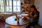 Molding craft ceramics: table in pottery studio with female artist shaping wet clay for potter bow