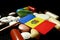 Moldovan flag with lot of medical pills isolated on black background