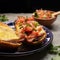 Molletes with ham, refried beans and melted cheese on a gray background. Mexican food