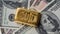 Molten gold bar weighing 250 gram against the background of dollar bills