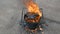 Molten hot tar in a bucket on bricks. Roof repair. Fire from bucket. Grid on bucket