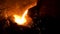 Molten steel being transferred from furnace to ladle in steel plant for further processing. Stock footage. Details of