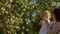 Mom with adorable daughter in white dress in her hands are sniffing flowers