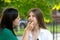 Mom applying lipstick to teenage daughter\\\'s lips