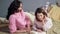 Mom attentively listening her daughter reading bedtime storybook, happy family