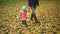 Mom with a baby in autumn park. Mum walks with the child in the autumn forest. Family walk in the nature in autumn. slow