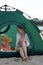Mom and baby play in tourist tent at the campsite. Camping with children. Family vacation. Vertical frame