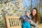 Mom and baby rejoice in the spring. flowering trees. Happy mom and daughter rejoice each othe