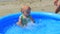 Mom bathes the child in the inflatable pool