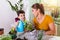 Mom and boy child water the plants together, Momâ€™s little gardener assistant, taking care of children and flowers. Cute boy