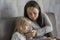 Mom calms a crying little girl on the couch. Concept: children`s whims and tantrums, formation of the child`s personality, care