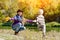 Mom catches running son. Autumn, a sunny day. River bank