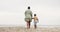 Mom, child and holding hands on beach sand for support, bonding and walking outdoor on holiday. Back of parent, mother