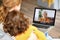 Mom and child making talking with grandma through video call on laptop