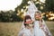 Mom and child sitting near teepee wigwam tent and biting ripe watermelon