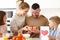 Mom with children congratulating dad with Fathers day while having breakfast in kitchen