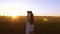 Mom and children laugh while walking along the road with wheat in the glare of the setting sun. Slow motion.