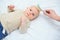 mom combs the baby with a special hair brush on a white background.