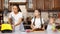 Mom cooks cream for cake using blender with her two daughters.