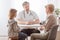 Mom and cute sick son in front of the handsome pediatrician`s desk