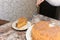 Mom cuts and serves a piece of freshly baked cake, which they have just made at home. The girl baked a cake and slices it