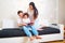 Mom, dad and baby read a book on the couch in the room. Parents