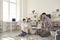 Mom, dad, daughter and son play game sitting at a table from which a wooden tower falls.